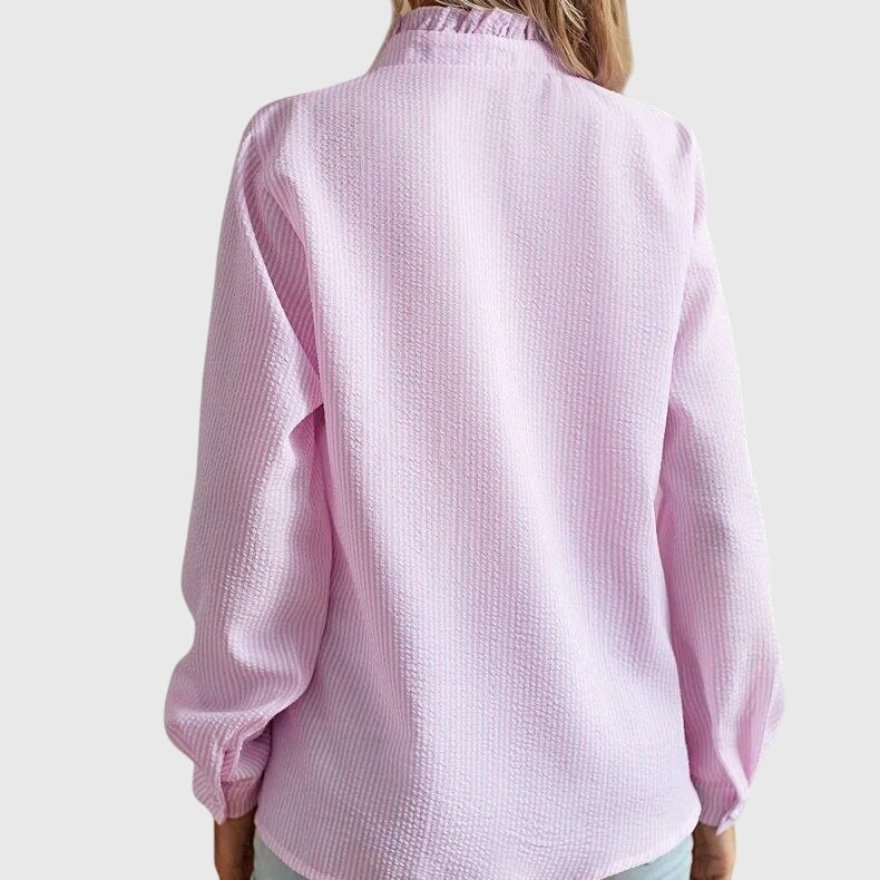 Pink textured blouse worn by a person on a white background