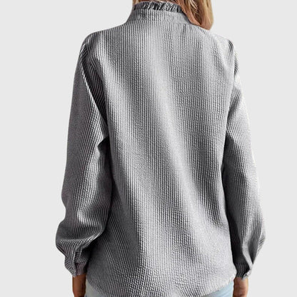 Person wearing a textured gray shirt on a white background